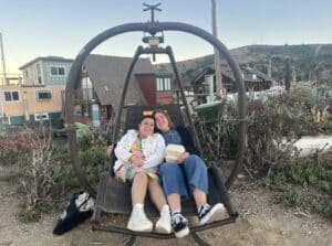 Lena with a friend on a swing.