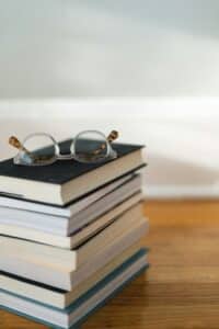 Photo of books in a pile with reading glasses