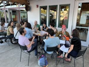 group of people sitting around a table talking together