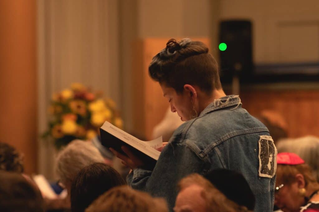 Young person reading from a religious text.
